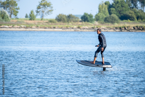 Silhouetted man on a hydrofoil surfboard