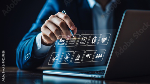 A businessman uses a futuristic interface to manage Enterprise Resource Planning (ERP), symbolizing the integration of complex business processes through advanced digital systems.