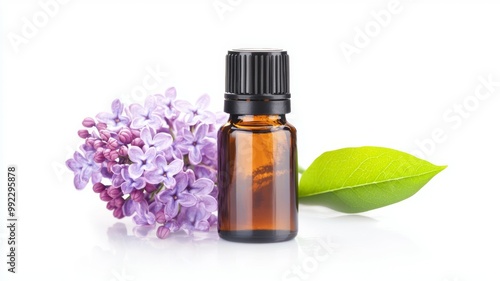 A bottle of essential oil is next to a purple flower