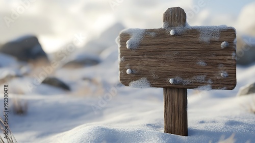 Wooden sign in a snowy landscape with rocks.