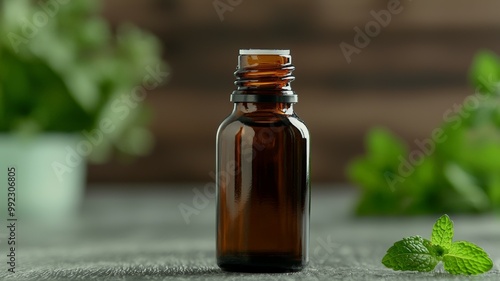 A bottle of essential oil is sitting on a table next to a potted plant