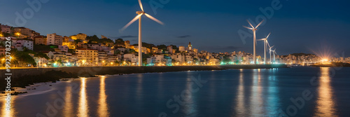 Eolic  Wind Turbines Energy Supplies Electricity to a City at Nigh. Distribution of Clean and Sustainable Energy Power photo