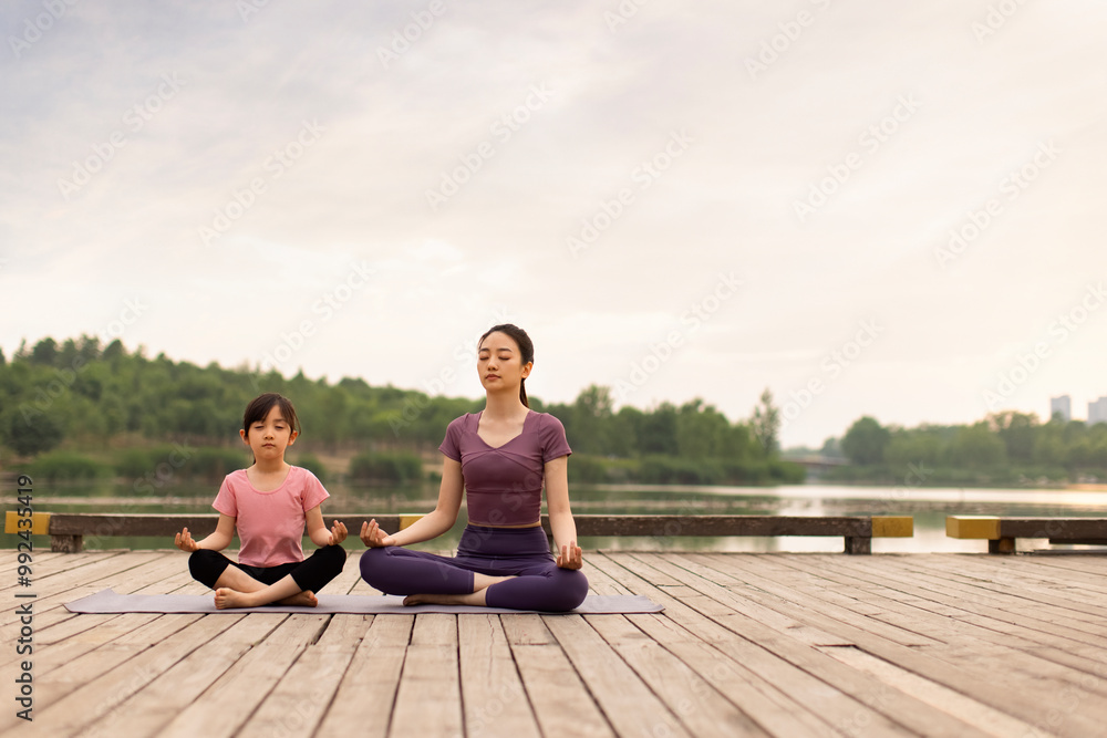Mom And Daughter Doing Yoga In A Park Mom And Daughter Doing Yoga In A Park