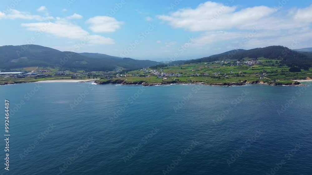 An approaching drone shot from the ocean to the coastline in summer, in Lugo, Galicia. An approaching drone shot from the ocean to the coastline in summer, in Lugo, Galicia.