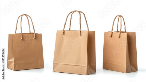 A set of eco-friendly brown paper shopping bags with handles, isolated on a clean white background