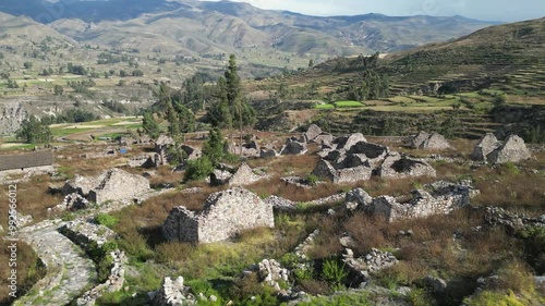 Aerial orbits long abandoned stone ruins of Uyo Uyo site in Peru photo