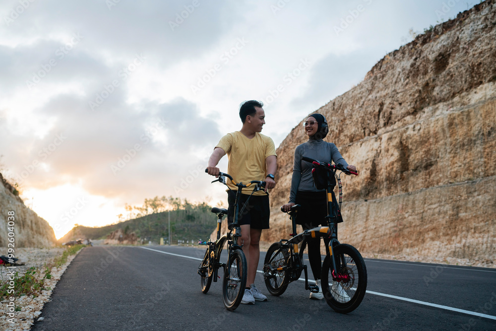 Fototapeta premium male and female biker riding bike together