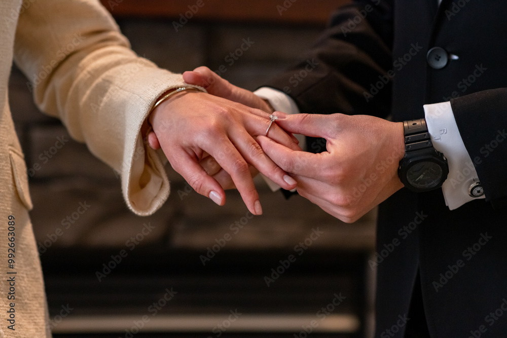 Male groom putting on a diamond wedding ring on a female bride. Wedding ceremony. Male groom putting on a diamond wedding ring on a female bride. Wedding ceremony.
