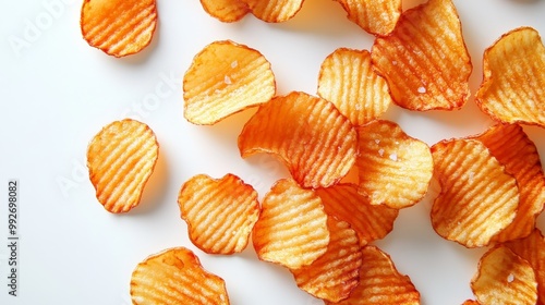 A close-up view of crunchy potato chips, lightly salted with visible ridges, spread out evenly on a pristine white background, sharp and clear texture photo