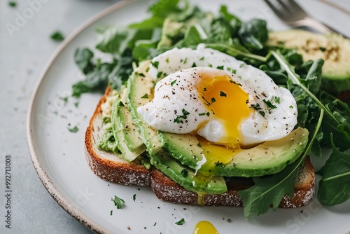 Avocado toast with poached eggs and crisp greens, placed on a modern white plate for a minimalist and nutritious breakfast