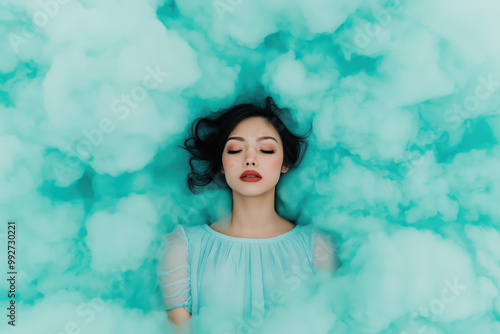 Dreamy portrait of a woman lying in soft blue clouds with peaceful expression