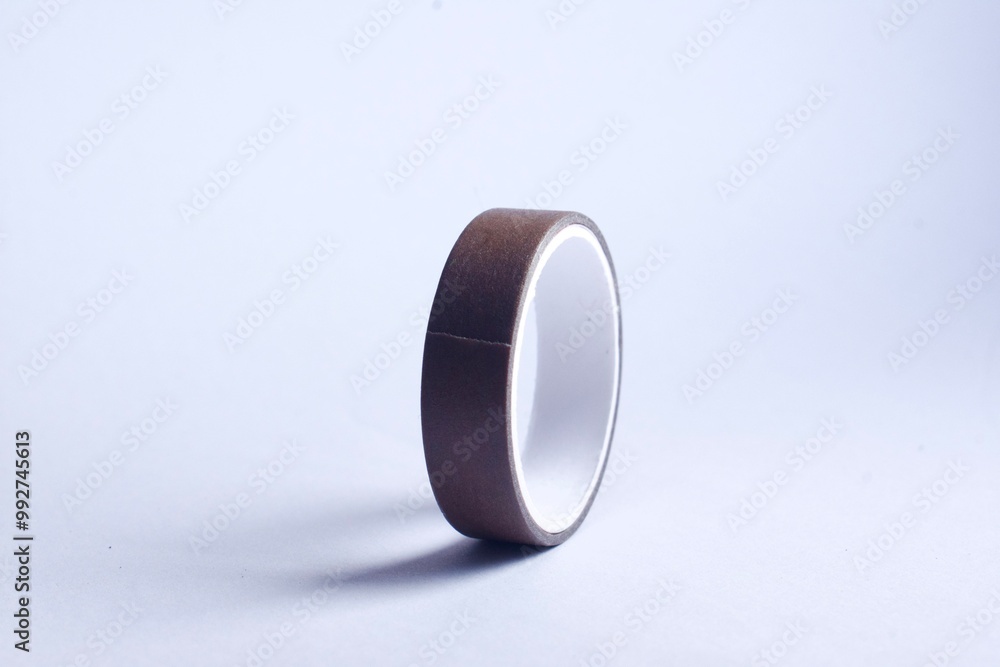 A roller of brown washi tape on white background A roller of brown washi tape on white background