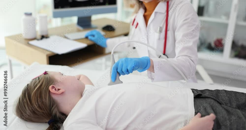 Doctor in white coat examines heart of schoolgirl using ultrasound convex linear transducer. Female medical specialist checks up condition of cardiovascular system of patient Doctor in white coat examines heart of schoolgirl using ultrasound convex linear transducer. Female medical specialist checks up condition of cardiovascular system of patient