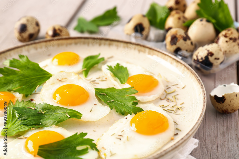 Plate with fried quail eggs and parsley on grey wooden background Plate with fried quail eggs and parsley on grey wooden background