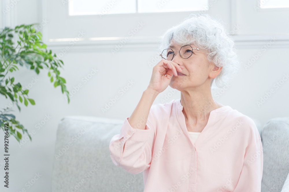 鼻水をすする高齢者女性. 鼻水をすする高齢者女性.