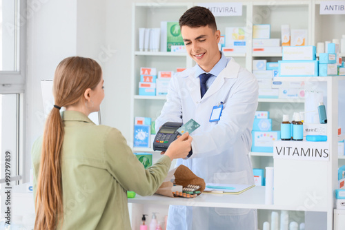 Male pharmacist receiving payment for medications at pharmacy