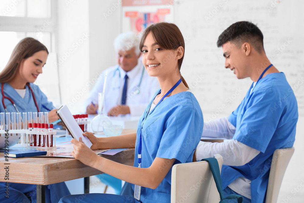 Fototapeta premium Female medical student with notebook at lecture