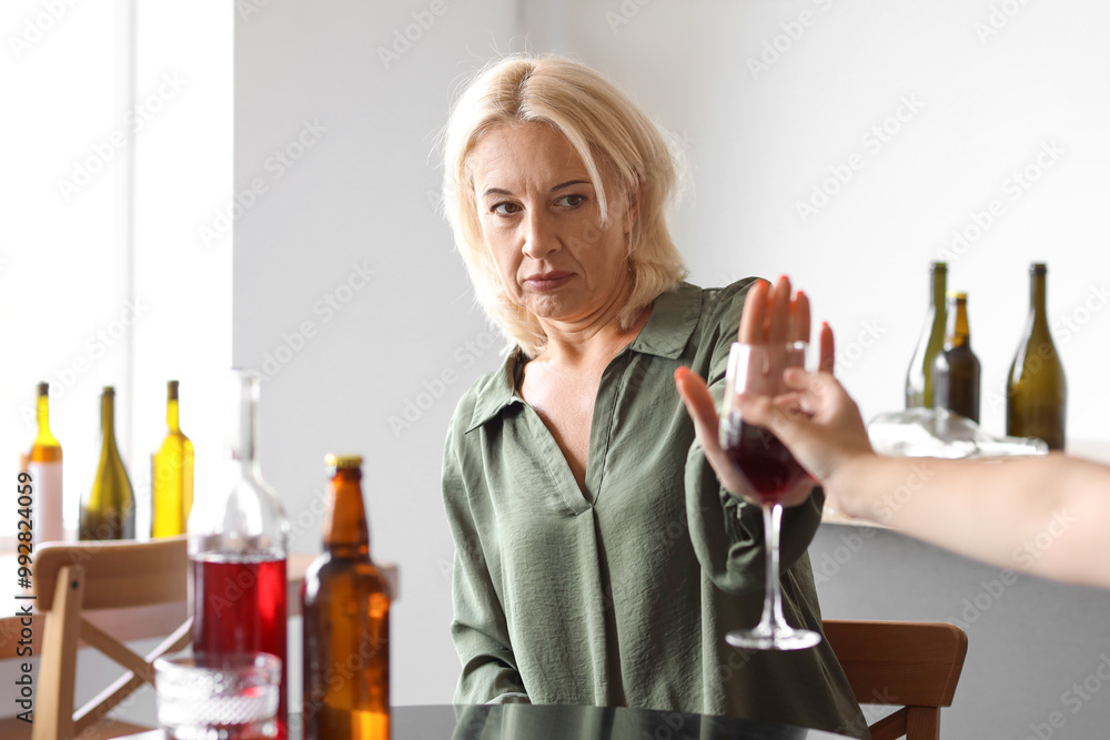 Mature woman rejecting suggested glass of alcohol. Concept of healthy lifestyle Mature woman rejecting suggested glass of alcohol. Concept of healthy lifestyle