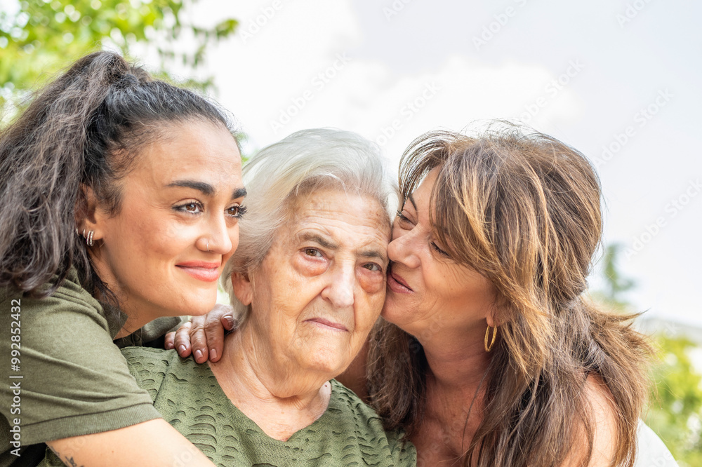 Group Of Women Hugging Each Other Tightly, With The Grandmother At The Center, Laughing Joyfully As She Receives The Overflowing Affection And Warm Embrace From Her Family Members, Full Of Love Group Of Women Hugging Each Other Tightly, With The Grandmother At The Center, Laughing Joyfully As She Receives The Overflowing Affection And Warm Embrace From Her Family Members, Full Of Love