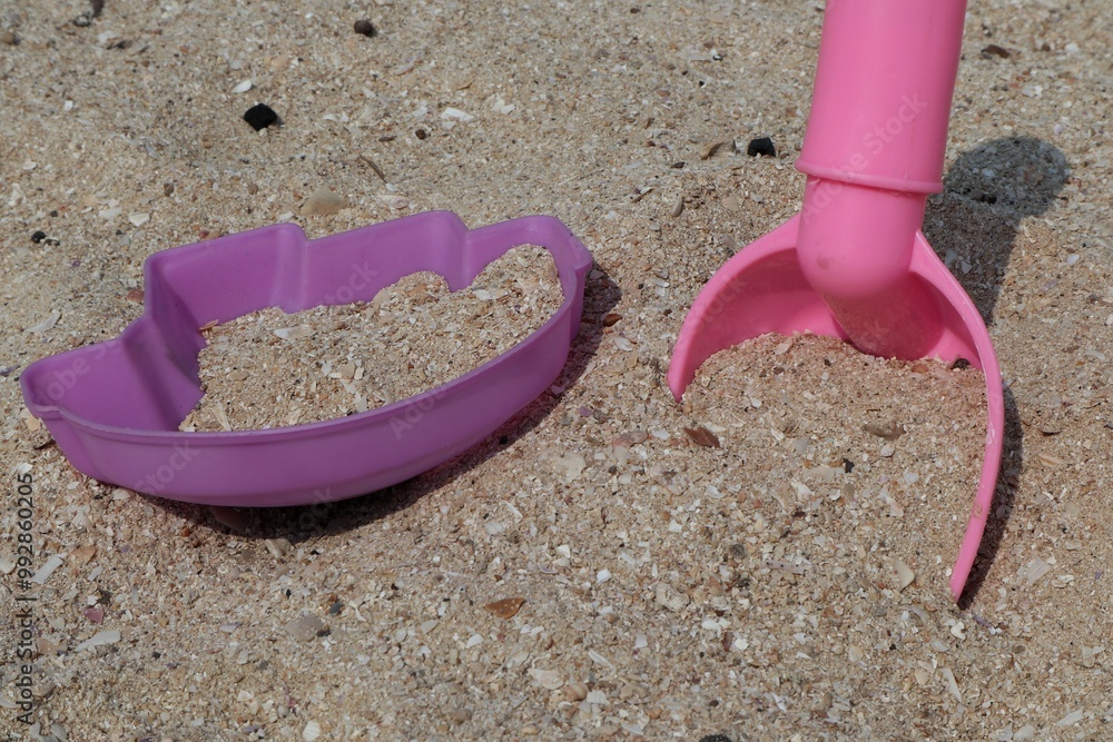 Pink shovel Sandy playground or beach with children's toys.