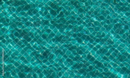 Blurred image of water and tiles in pool. Water waves and reflection in swimming pool photo