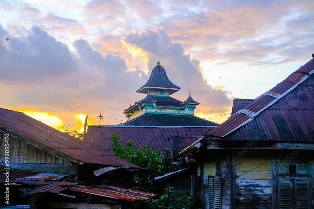 Masjid Jami' Kesultanan Kadariyah Pontianak in Kampung Beting, featuring traditional Malay architecture, green-yellow tones, wooden structures, and historical Islamic heritage.