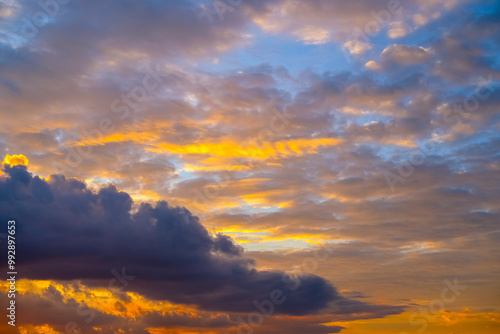 Dramatic sunset paints the sky with vibrant shades of orange, pink, and dark purple, silhouetting buildings below and creating a breathtaking evening scene full of depth and color.