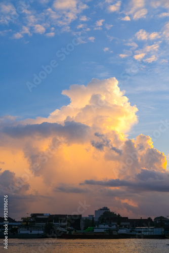 Obraz na płótnie Sunset over Pontianak cityscape at Kapuas River’s edge, with vibrant blue and orange clouds reflecting on the water, capturing the serene beauty of the riverside city. w salonie