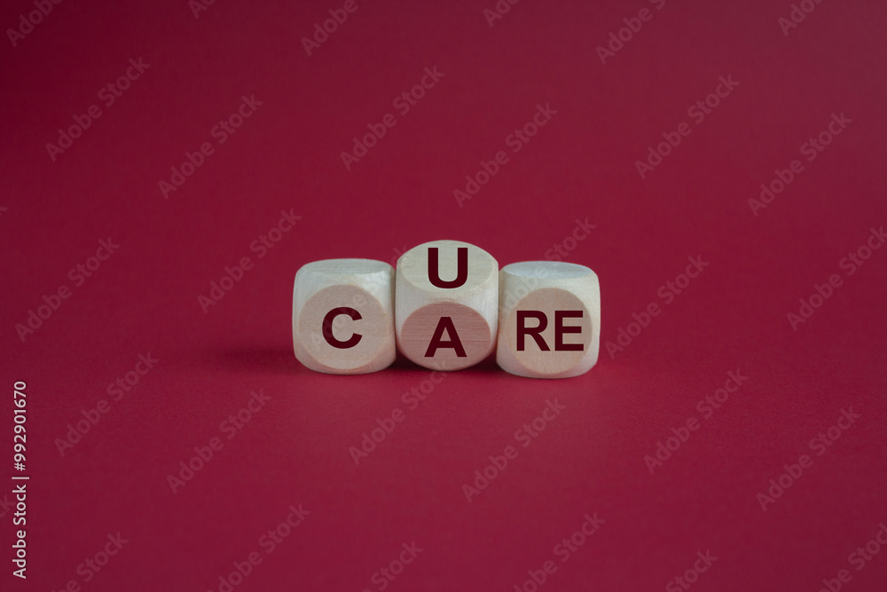 Turned a wooden cube and changes the word 'care' to 'cure'. Beautiful pink background, copy space. Business, medical, cure and care concept. Turned a wooden cube and changes the word 'care' to 'cure'. Beautiful pink background, copy space. Business, medical, cure and care concept.