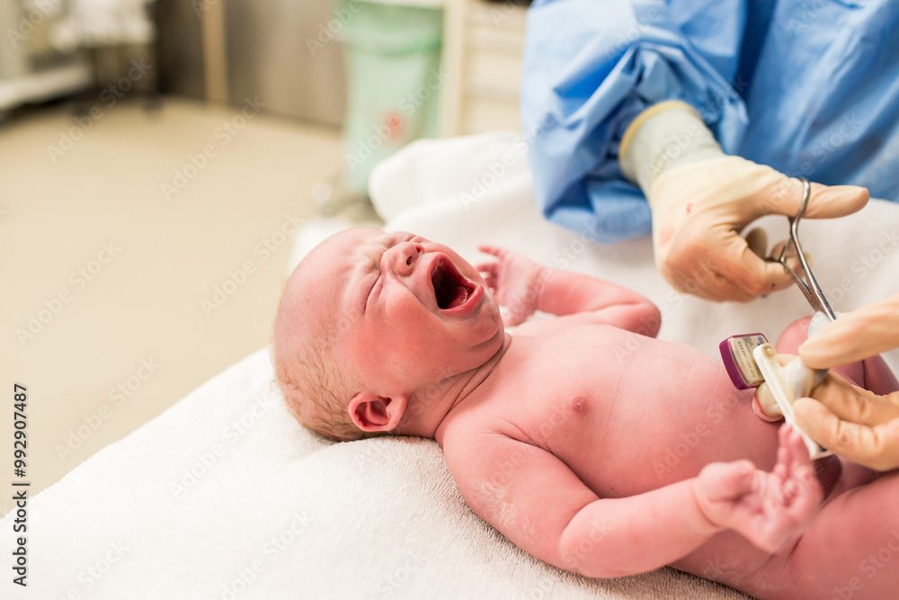 Nurse Cutting Umbilical Cord in Operating Room on Newborn Baby Boy Nurse Cutting Umbilical Cord in Operating Room on Newborn Baby Boy