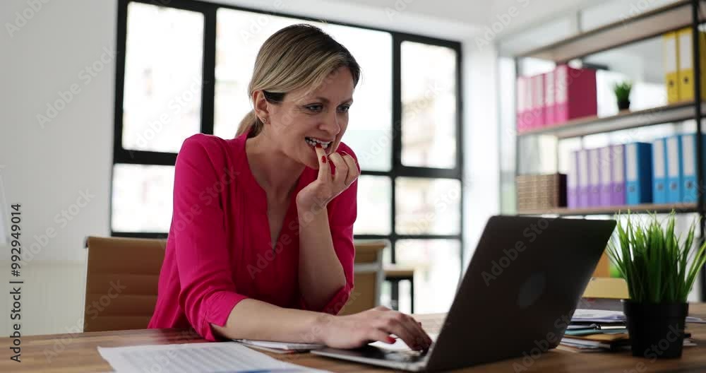 Worrying young employee waits for result of interview with new boss. Lady bites nails in excitement while sits at laptop on table. Bad habit concept Worrying young employee waits for result of interview with new boss. Lady bites nails in excitement while sits at laptop on table. Bad habit concept