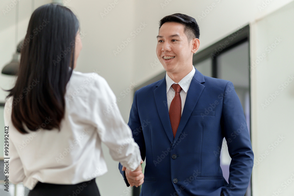 A professional handshake between a man in a suit and a woman in a blouse, symbolizing business collaboration or agreement in a modern office setting. A professional handshake between a man in a suit and a woman in a blouse, symbolizing business collaboration or agreement in a modern office setting.