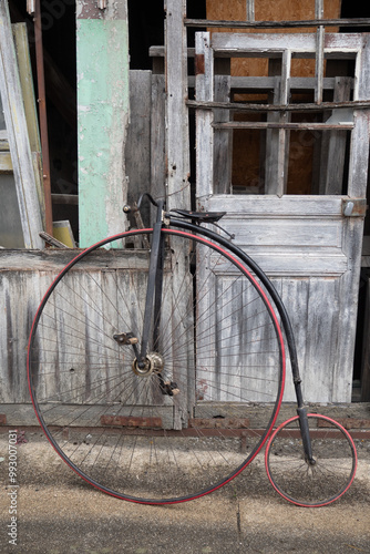 Photos Penny farthing leaning against a weathered door of an old workshop