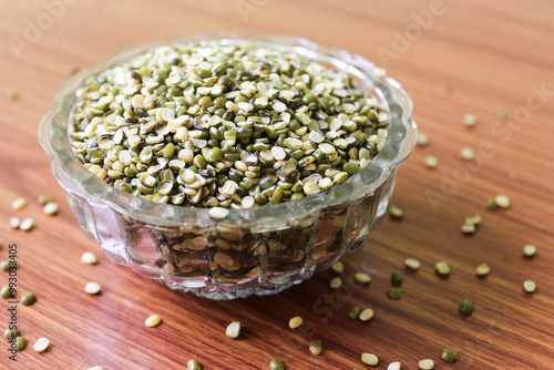 Split Mung Bean Lentils Also Know as Mungbean, Mung Gram, Vigna Radiata, Green Gram, Golden Gram Legumes, Moong Bean, Moong Dal, Green Bean or Mung Daal in bowl on wooden background
 photo