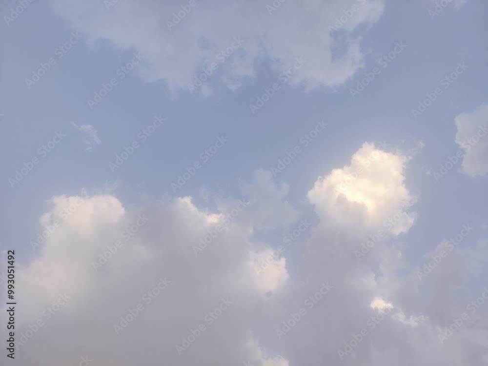 The photo captures the calming essence of nature, with the gentle light of the sun illuminating the edges of the clouds, creating a dreamy and tranquil atmosphere. The simplicity and purity of the sky The photo captures the calming essence of nature, with the gentle light of the sun illuminating the edges of the clouds, creating a dreamy and tranquil atmosphere. The simplicity and purity of the sky