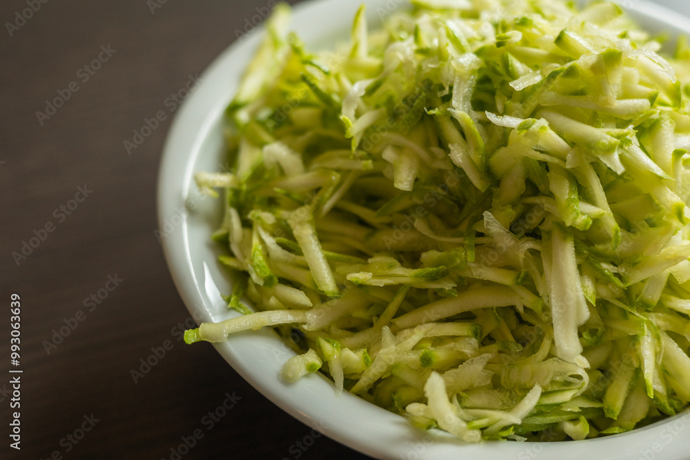  Shredded Zucchini in a White Bowl Close-Up on Dark Background