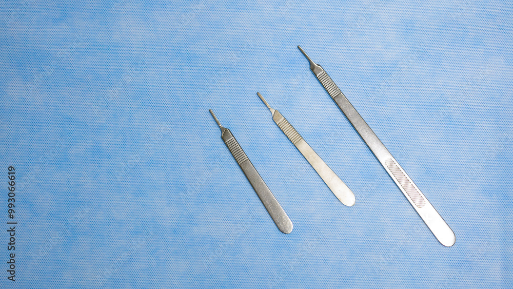 Stainless Medical instruments used for surgery placed on a blue background. Surgical instruments. Medical equipment. Medical science and surgery concept. Stainless Medical instruments used for surgery placed on a blue background. Surgical instruments. Medical equipment. Medical science and surgery concept.