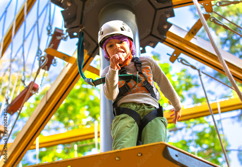 brave little boy in helmet climbing at adventure park in autumn season. Work out concept brave little boy in helmet climbing at adventure park in autumn season. Work out concept
