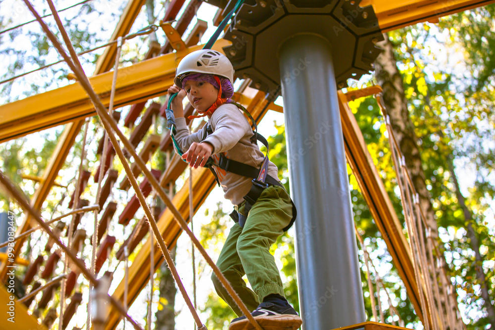 brave little boy in helmet climbing at adventure park in autumn season. Work out concept brave little boy in helmet climbing at adventure park in autumn season. Work out concept