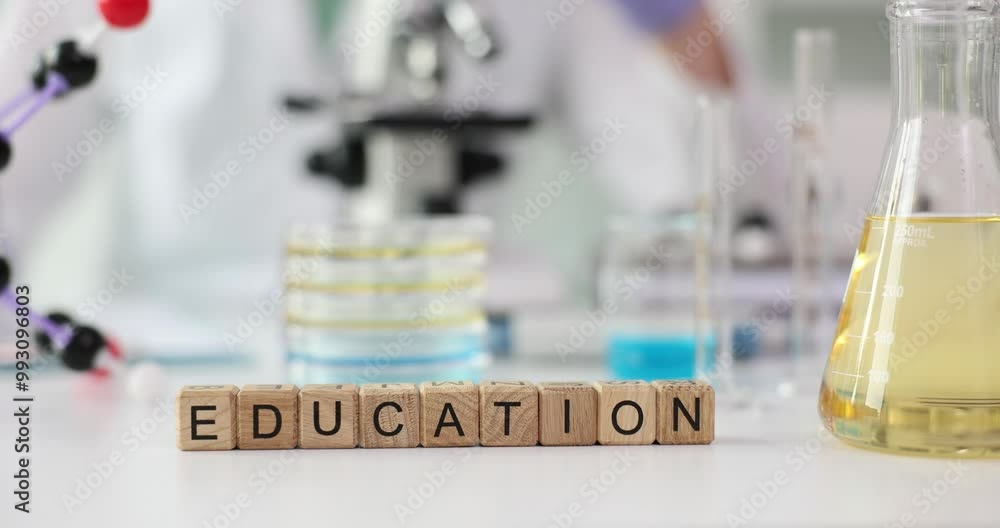 Word Education made of wooden cubes on laboratory table against flask of reagent, glass Petri dishes and microscope. Practical training in medical institution lab Word Education made of wooden cubes on laboratory table against flask of reagent, glass Petri dishes and microscope. Practical training in medical institution lab