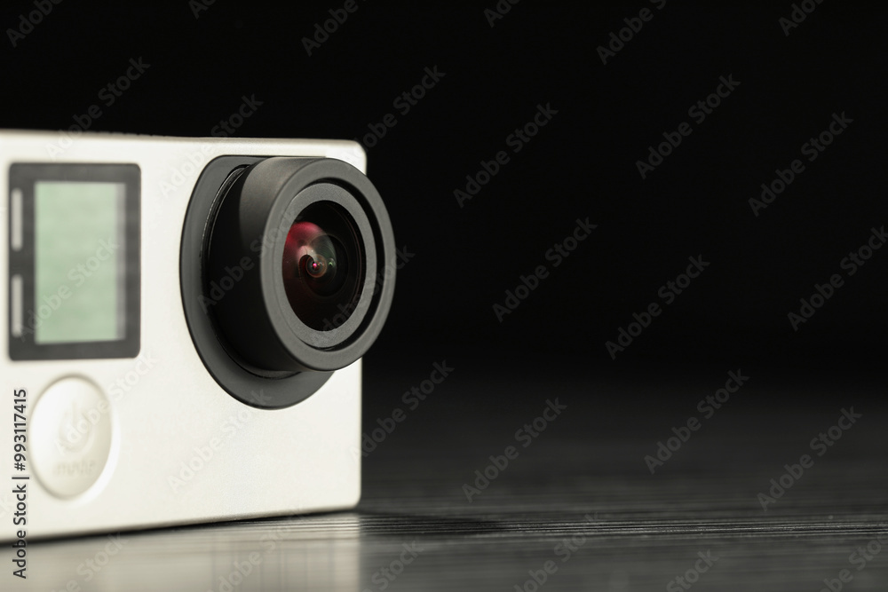 Modern action camera on wooden table against black background, closeup. Space for text Modern action camera on wooden table against black background, closeup. Space for text