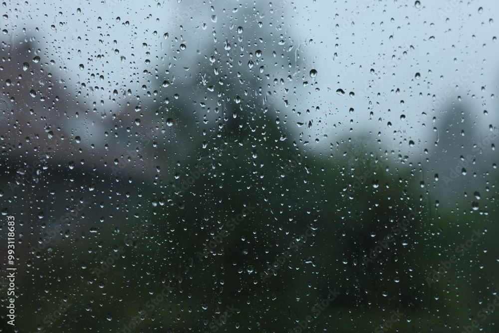 View on buildings through window with water droplets on rainy day, closeup View on buildings through window with water droplets on rainy day, closeup