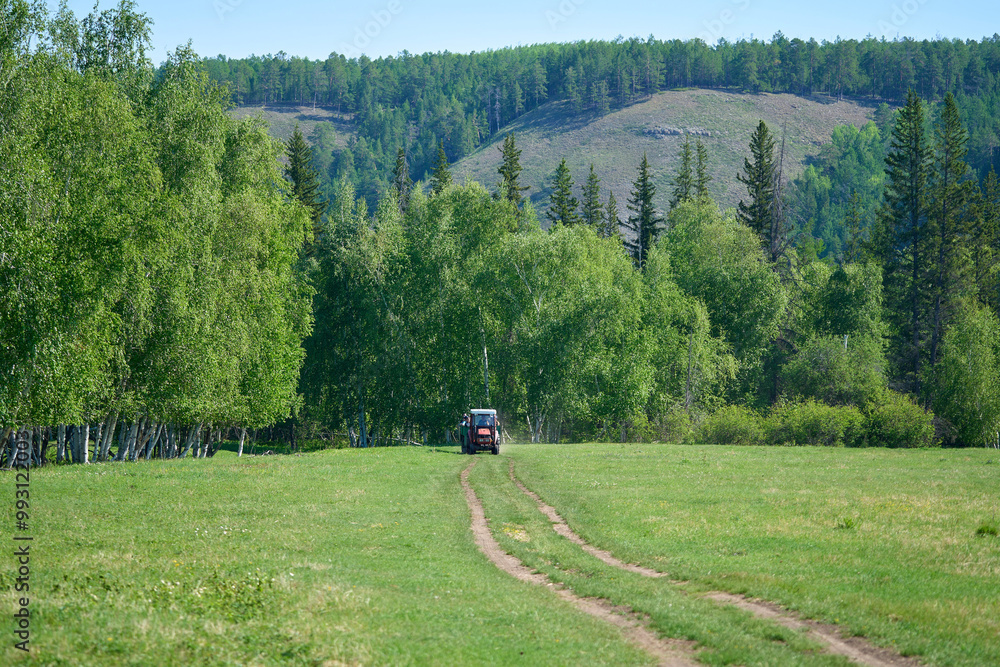 A tractor is driving across a field in Siberia A tractor is driving across a field in Siberia