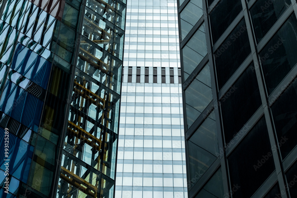 Three skyscrapers with contrasting architectural styles and materials, including glass and steel, highlighting the diversity of design in a dense urban environment. Three skyscrapers with contrasting architectural styles and materials, including glass and steel, highlighting the diversity of design in a dense urban environment.
