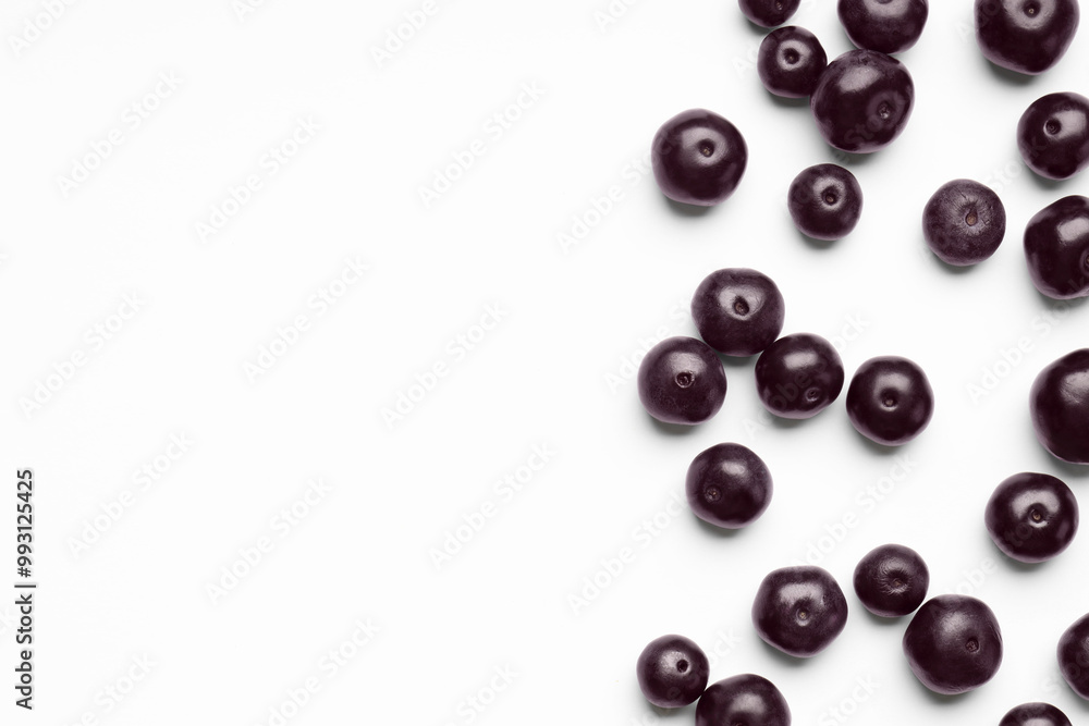 Ripe acai berries on white background, flat lay. Space for text Ripe acai berries on white background, flat lay. Space for text
