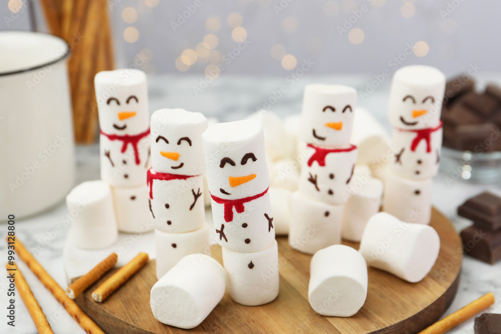 Funny snowmen made with marshmallows on white marble table, closeup Funny snowmen made with marshmallows on white marble table, closeup