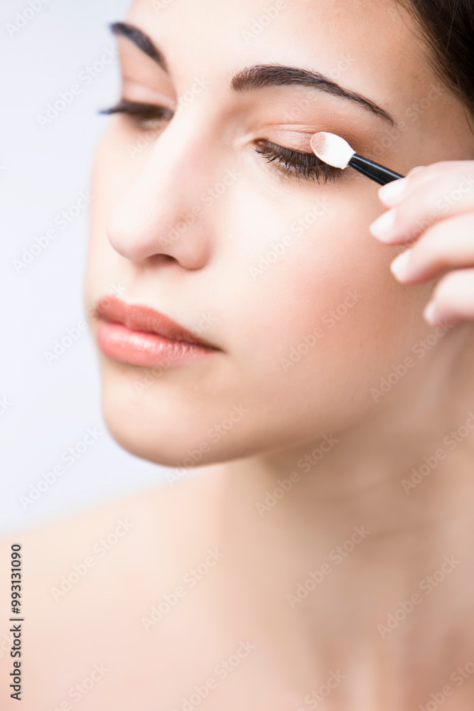 Profile up of a young woman applying eyeshadow
Profile up of a young woman applying eyeshadow