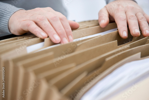 Close up of a man hands flicking through a file folder
