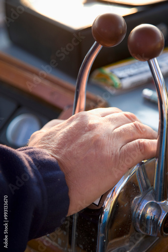 Close up of a man's hand on a boat throttle
 photo