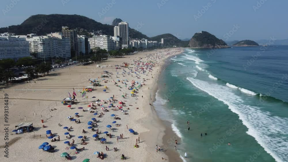 Vídeo de banhistas se divertindo na orla da Praia de Copacabana, Rio de Janeiro, mostrando a praia movimentada, o mar e as pessoas aproveitando o dia de sol em um dos destinos mais famosos do Brasil